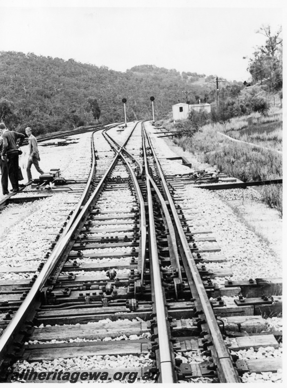 P17854
Jumperkine, in the Avon Valley, and the points trackwork for the dual gauge access from the bypass loop to the main line. ER line. Note the automatic signals and signalling equipment buildings in background. The points show the rodding utilised for each set and the points machine to the left.
