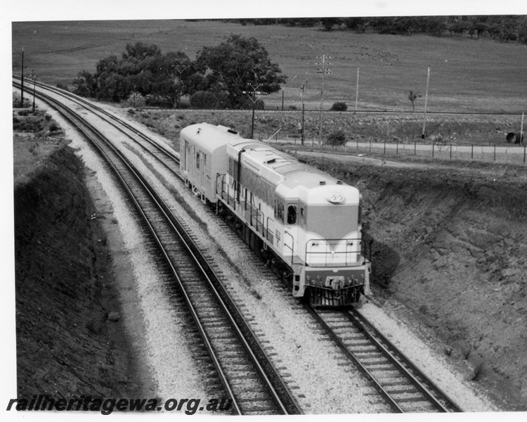 P17855
K class 203 diesel locomotive with an unidentified WBA class brakevan performing high speed trials at Lloyds crossing east of Toodyay. In the background can be seen the former Clackline - Toodyay formation. Overhead view of locomotive and brakevan.
