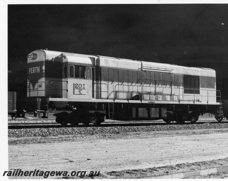 P17875
K class 201 standard gauge diesel locomotive at Northam on its delivery run from Queensland. Note the narrow gauge transfer bogies and match wagons at each end. ER line.
