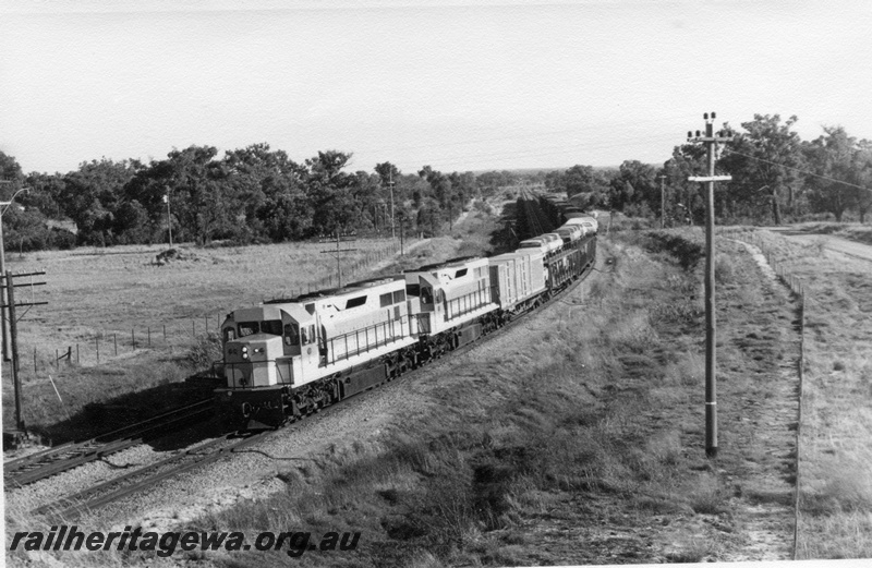 P17900
L class diesel locomotives double heading train, including car carriers, rural scene, front and side view, c1970
