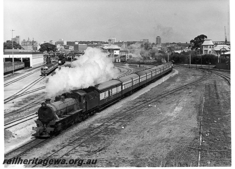 P17918
W class 958 on Wapet Special, sheds, overhead footbridge, signal box, city skyline, front and side view
