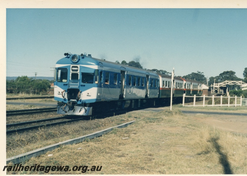 P17948
ADX class 670 railcar in blue and white livery, heading 3 car suburban railcar set, station building, pedestrian overpass, track level pedestrian crossing, Guildford, ER line
