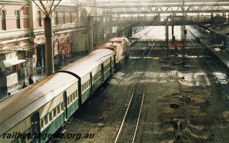 P18064
7 of 11 Construction of new Perth City station, A class 1510 with empty carriages from Claisebrook for Armadale service, arriving platform 4, new roof framework and supports, pedestrian overpass, Perth City station
