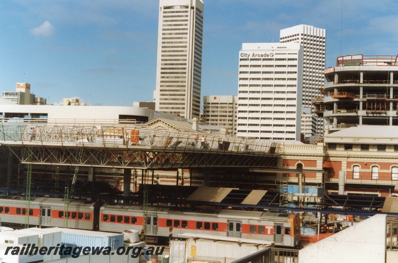 P18311
ADL class railcar and ADC class railcar, Perth City station under reconstruction, constructors huts in foreground, city buildings in background 
