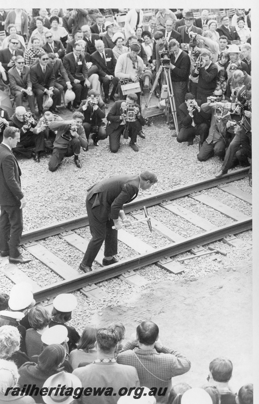 P18477
8 of 12 images relating to the ceremony for the linking of the standard gauge railways at Kalgoorlie, Commonwealth Minister of Shipping and Transport Ian Sinclair drives home the final gold dog spike to link the standard gauge railways
