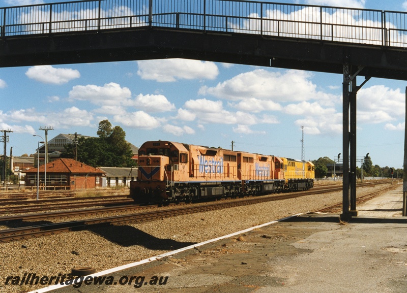 P18655
Q class 316 standard gauge diesel locomotive on trail with L class 260 and 268 at Midland. First 2 locomotives in Westrail Orange paint scheme and Q class in yellow. Position of overhead footbridge from old Midland station to Workshops is visible. 
