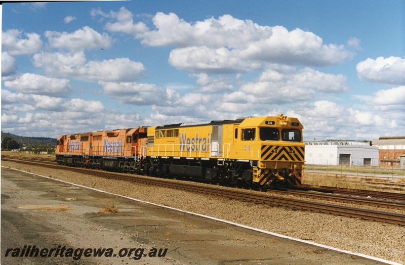 P18656
Q class 316 standard gauge diesel locomotive on trail through Midland with L class 260 and 268. Steel building in right background was formerly used as temporary Terminal Building at East Perth Terminal. ER line.
