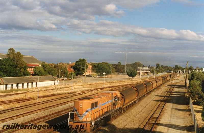 P18662
D class 1561 heading an empty mineral sands train of XE class hopper wagons to Chandalla, on the Midland Railway line, passing through Midland. The white building to the left of the locomotive is the former workshop workers bicycle shed.
