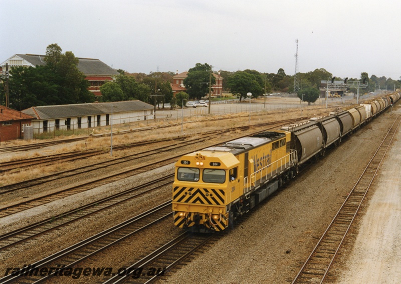 P18663
Q class 303 standard gauge diesel locomotive hauling an empty grain train through Midland in a eastbound direction. The locomotive is painted in Westrail yellow. ER line.
