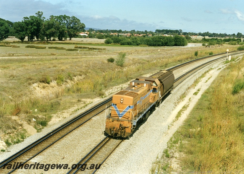 P18669
A class 1511 diesel locomotive enroute to Goninan works at Bassendean with a narrow gauge wheat wagon for repairs, 

