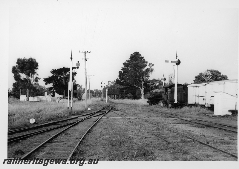 P18709
Station platform, station nameboard, platform lights, end of passing goods train, passenger shelters, North Fremantle, ER line 
