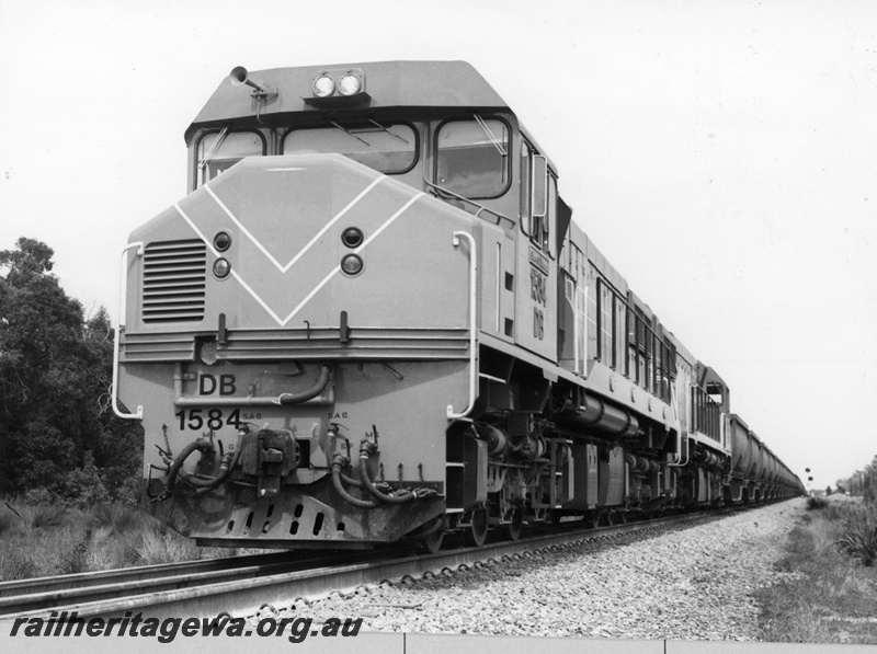 P18715
NA class 1873, in Westrail orange with white edged blue stripe, on goods train, side and front view
