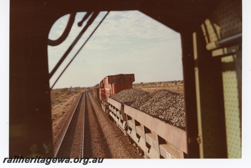 P18735
Mount Newman (MNM) M636 class 5495 on ballast train (Difco ballast wagons) at Turner. Rear view photo taken from cab of passing ore train. 
