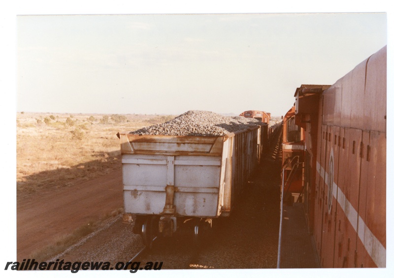 P18736
Mount Newman (MNM) rear view of ballast train at Turner siding - former Oroville Dam ore wagons. Photo taken from passing ore train.
