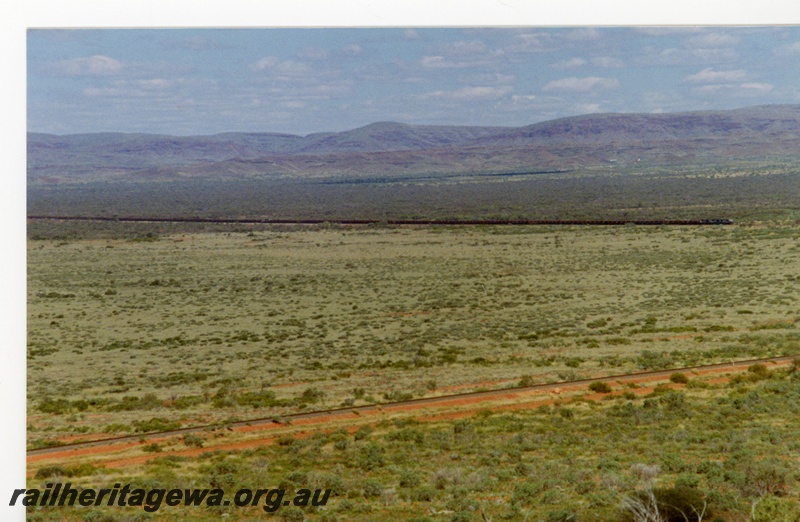 P18789
Mount Newman (MNM) 220 car Locotrol ore train crosses Fortescue flood plain at 255kp - shows full length of train. 
