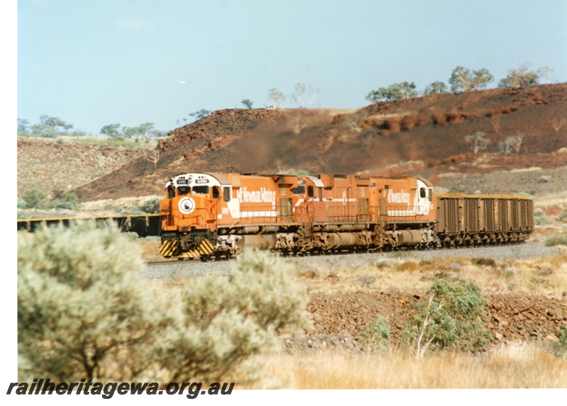 P18791
Mount Newman (MNM) M 636 class 5495, 5467, 5477 haul loaded ore train near Garden. 
