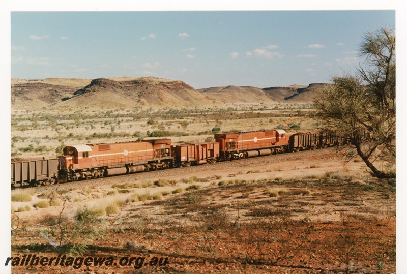P18794
Mount Newman (MNM) M636 class 5470, 5469 Locotrol units in centre of train near Garden. Mesa's in background.
