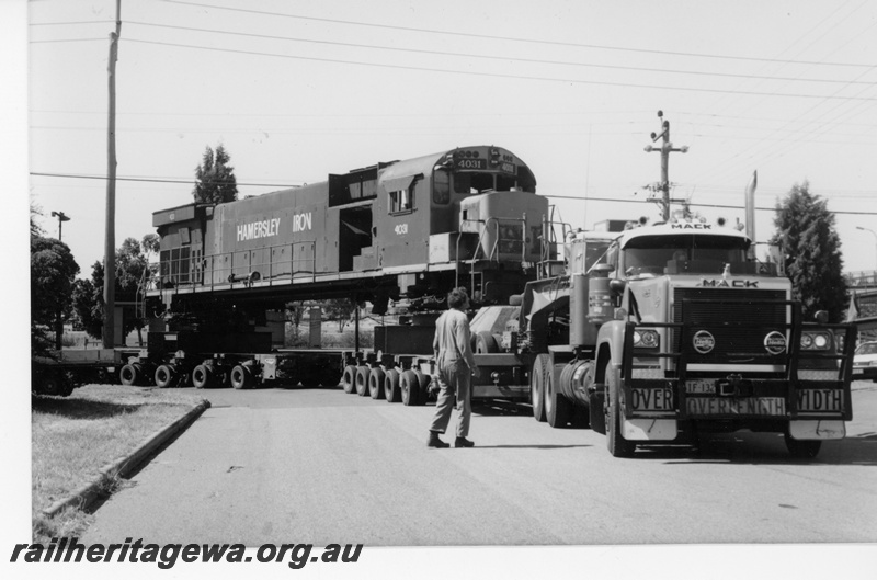 P18799
Hamersley Iron (HI) M636 class 4031 on low loader at corner of Railway Pde. and Wood Street, Bassendean en route to Comeng for rebuilding. 
