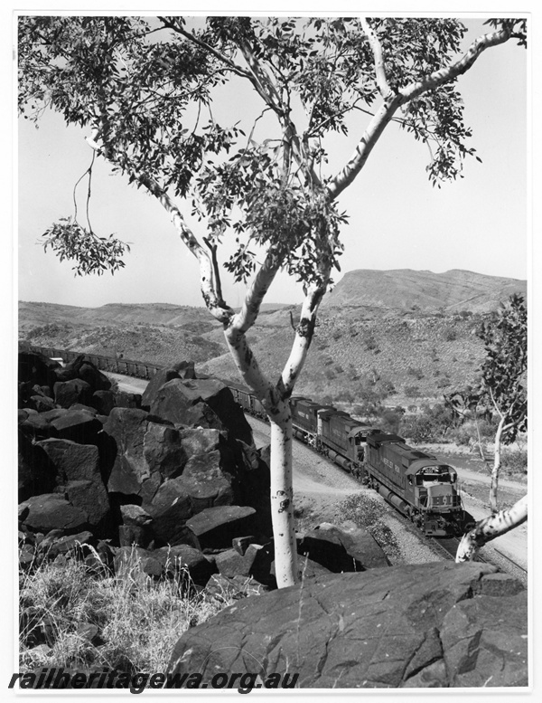 P18812
Hamersley Iron (HI) M636 class 4033, 4047, 4030 entering Bell's Cutting near Wombat hauling a loaded train to Dampier. Mount Nameless in background. 
