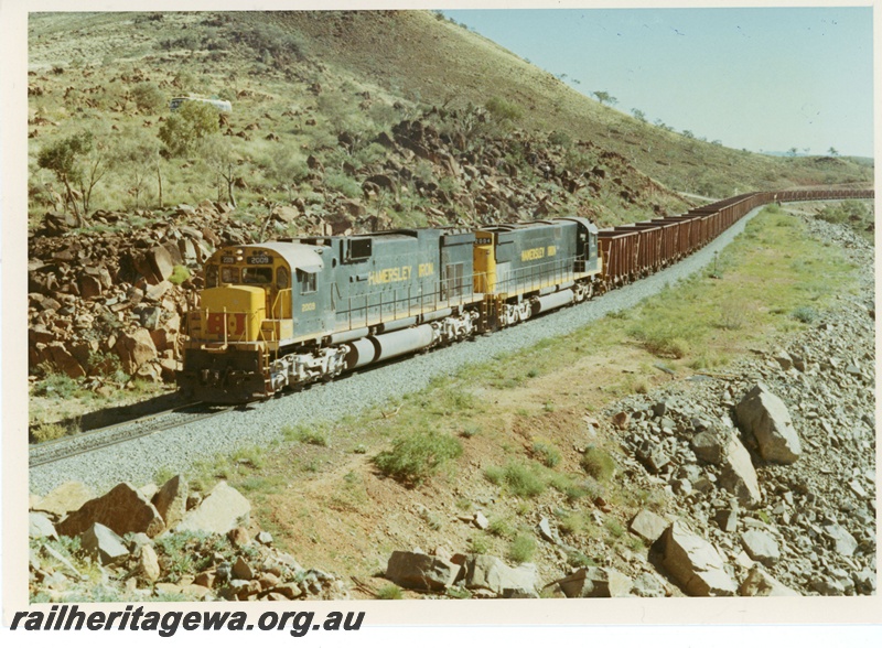 P18843
Hamersley Iron (HI) C636 class 2009 C628 class 2004 loaded iron ore train approaching bells cutting near Wombat.
