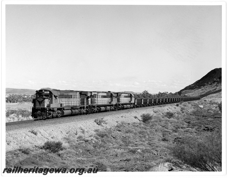 P18911
Cliffs Robe River (CRRIA) M636 class 9410,9412,9411 haul loaded iron ore train across the Harding River flood plain.
