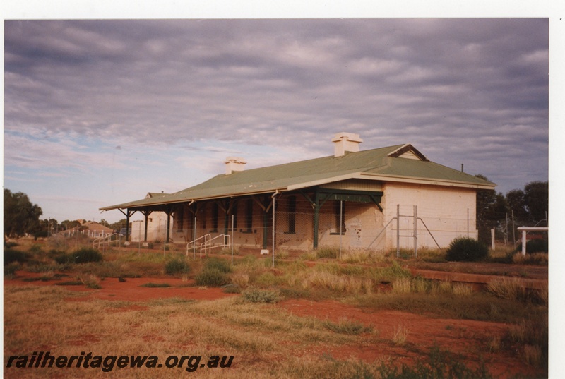 P18988
Station building, Cue, abandoned and overgrown with weeds, trackside and end view, NR line
