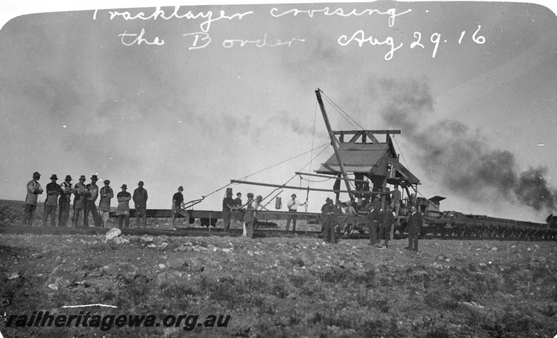 P19156
Commonwealth Railways (CR) tracklayer train, workers, crossing the border, TAR line, track level view
