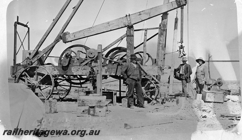 P19198
Commonwealth Railways (CR) bore casing, beam and engine, workers, 497 mile bore, TAR line
