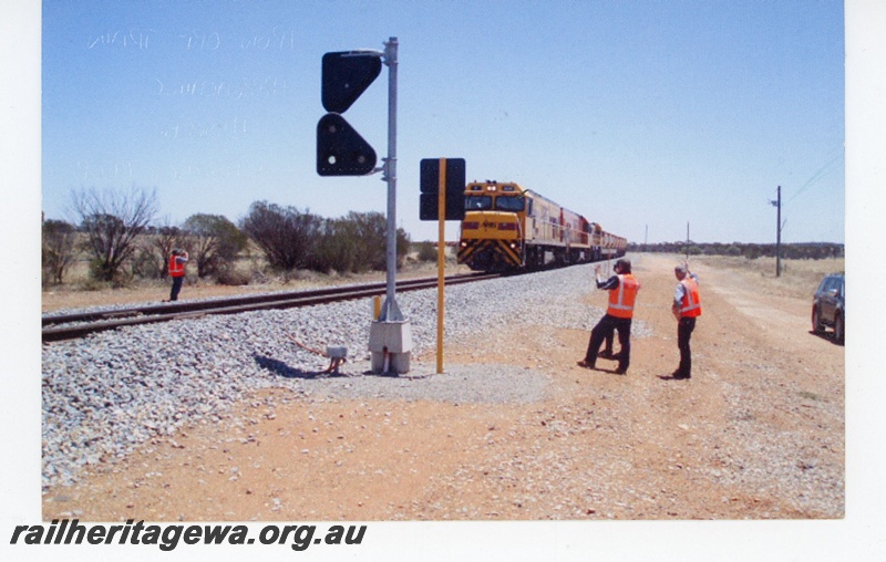 P19326
Australian Railroad Group liveried diesel locos, double heading iron ore train, loop signal, onlookers, approaching Monger crossing loop, NR line, track level view, 
