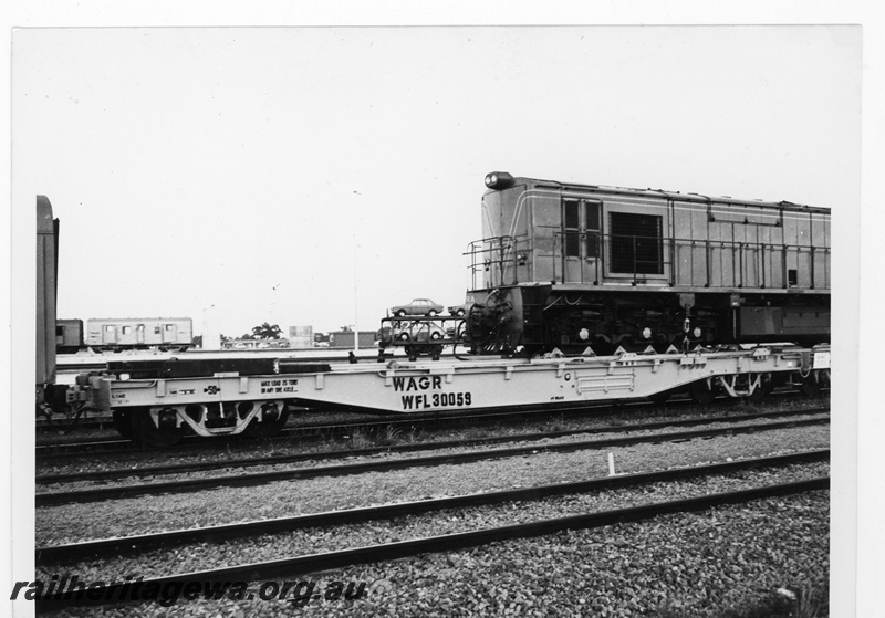 P19352
Westrail RA class diesel straddling standard gauge loco transporting flat wagon WFL class 30059 and an unseen WFL class
