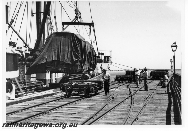 P19461
New coach wrapped in covers, being unloaded from the 