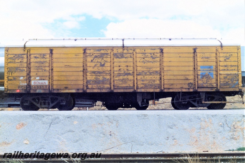 P19561
RCH class 24331-V, high sided wheat wagon with a roof, yellow livery with a blue Westrail symbol on the right hand end of the side, side view
