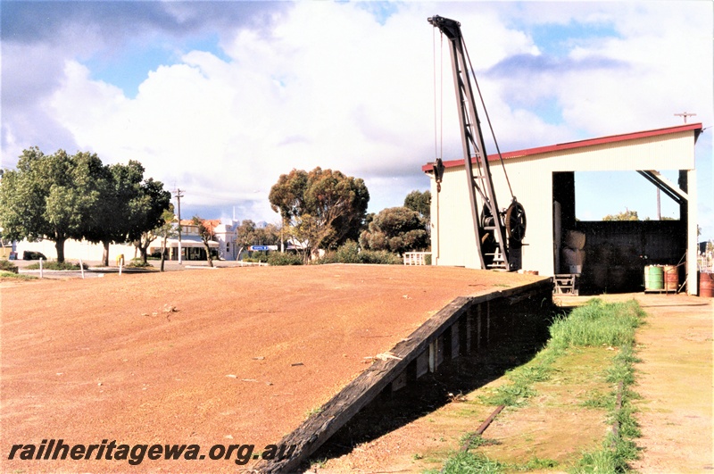 P19591
Loading platform, platform crane, goods shed, Wyalkatchem, GM line, track in front of the loading platform overgrown with weeds
