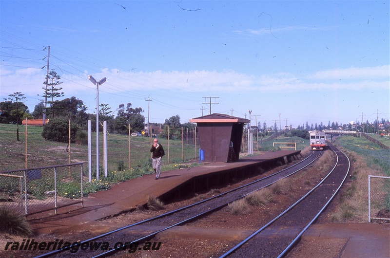 P19714
DMU having departed station, platform, shelter, platform lights, pedestrian track crossing, passenger leaving station, overpass in the distance, Grant Street station, ER line, track level view
