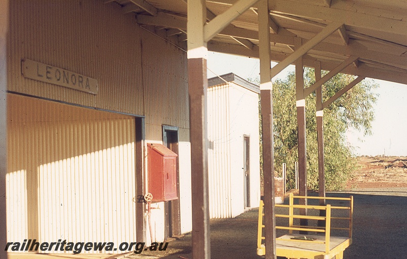 P19798
Station buildings, station nameboard, fire hose, platform, canopy supported by wooden posts and beams, luggage trolley, Leonora, KL line
