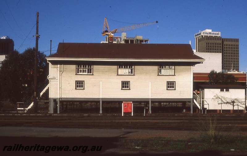 P19813
Signal box B, tracks, crane and city buildings in background, Perth station 
