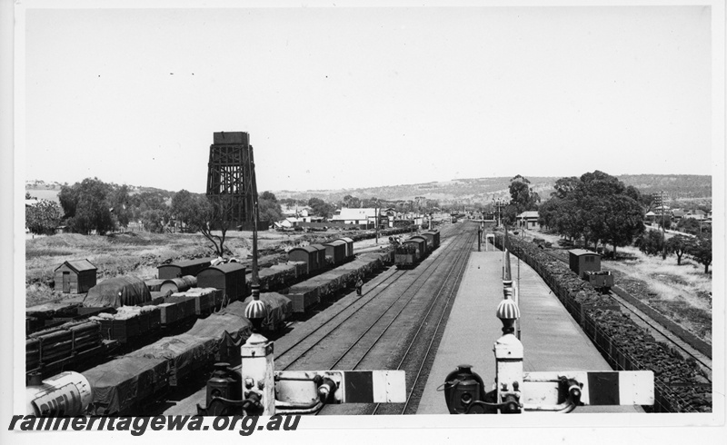 P20071
Northam station and yard, looking west from signal box, 50000 gallon water tank, rakes of goods wagons and vans, signals (tops only), bracket signals, sidings, platform, ER line, view from elevated position
