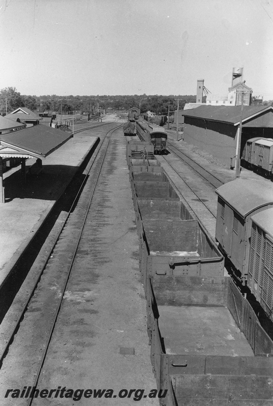 P20205
Platform, canopy, rake of wagons, carriages, vans, goods shed, yard, flour mill, colour light signals up main looking south, Narrogin, GSR line, view from elevated position
