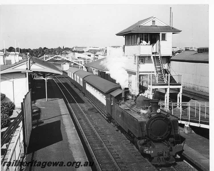 P20225
DD class 593 hauling short morning suburban passenger train to Perth at Subiaco (above ground) station. High signal box with signalman at washbasin on balcony. AYE class carriages. ER line.
