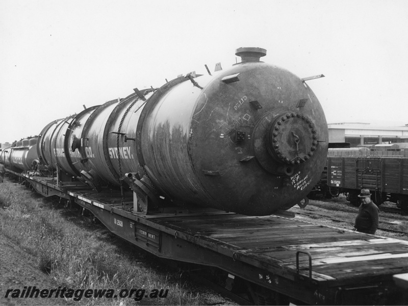 P20268
QU class wagon 25028 with fixed drawbar connection to another QU class wagon, loaded with a large 70 t 64 ft Bernard Smith Sydney pressure vessel, in transit from Cooks River to Kwinana, bolsters, worker, side and end view
