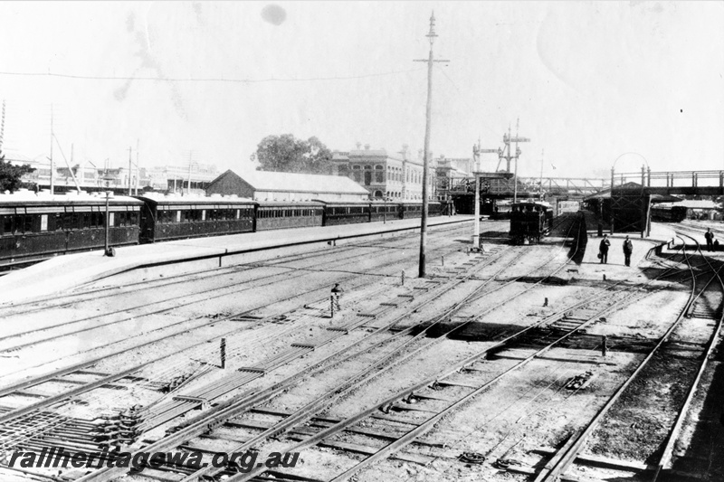 P20334
N class 207 with passenger carriage, another steam loco, station buildings, platform, tracks, points, rodding, bracket signals, overhead footbridge, several bystanders, signal, Perth station, view from eastern end 
