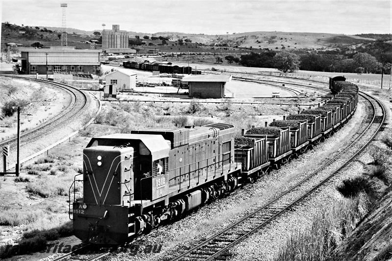 P20357
A class 1512, on iron ore train, wheat bins, sidings, wagons, yard buildings, antennas, train departing Avon Yard, Avon Valley line, front and side view from elevated position
