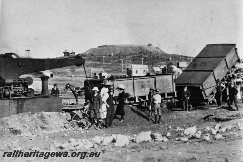 P20363
Commonwealth Railways crane tank loco No 1, TA class tank wagon, mine buildings, bystanders, Devon's Consul Gold Mine, Kalgoorlie, side view from trackside 
