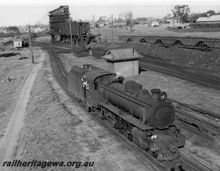 P20368
U class 664 at East Perth loco shed photographed looking down from Sumner Street footbridge. Original large wooden coaling stage in background, also row of XA class hopper wagons. ER line.
