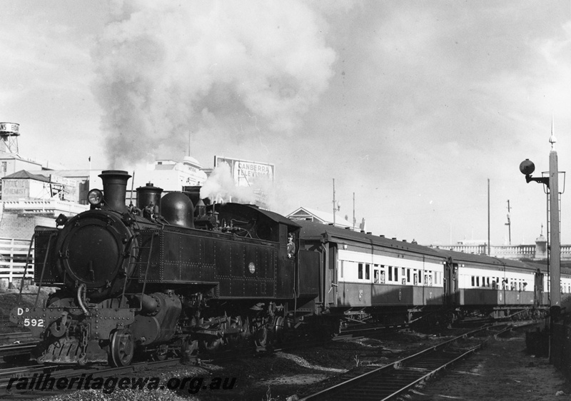 P20389
DD Class 592 hauling Down (eastbound) tour train of corridor coaches, Reso train, Barrack Street bridge, Perth buildings visible behind loco, elevated water tower carrying tank painted 