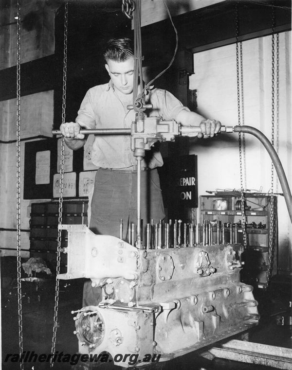 P20440
Engine block of AEC or BUT engine, with cylinders being honed by apprentice mechanical fitter, diesel shop, Midland workshops, ER line, interior view
