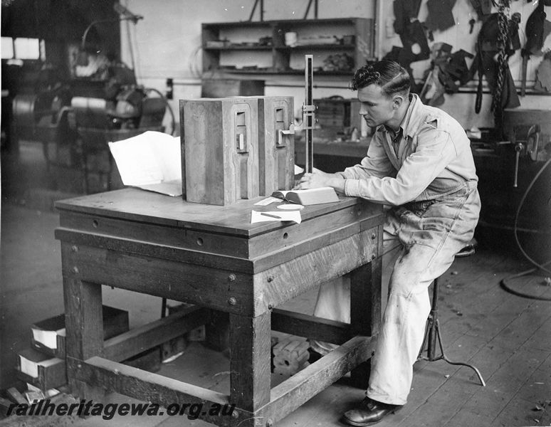 P20451
Worker on stool at bench, checking dimensions of drop forging dies for drawgear, with height gauge, Midland workshops, ER line, interior view
