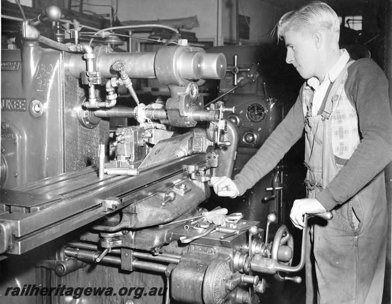 P20454
Milwaukee model H milling machine, worker machining flutes for reamer, example standing on table nearest camera, tool room, Midland workshops, ER line, interior view
