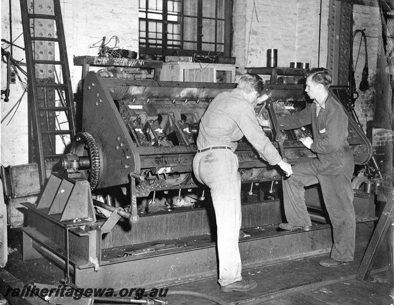 P20455
Engine on rotatable jig, ladder, fitter and apprentice tightening crankshaft main bearings with torque wrench, diesel shop, Midland workshops, ER line, interior view
