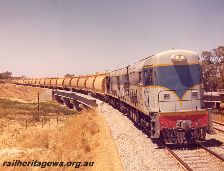 P20507
K class 202, and another K class loco, double heading a grain train, crossing a culvert, side and front view
